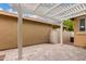 Backyard patio with a white pergola and desert landscaping with a beige exterior wall at 1162 S Agnes Ln, Gilbert, AZ 85296