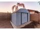 Backyard metal shed perfect for storage, set near a block wall and palm tree at 126 E Mclellan Rd, Mesa, AZ 85201