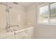 Accessible bathroom features a walk-in tub with a handheld shower and a bright window at 1332 E Redfield Rd, Tempe, AZ 85283