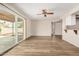 Open-concept living area with sliding glass doors to patio and modern laminate flooring under a ceiling fan at 1332 E Redfield Rd, Tempe, AZ 85283