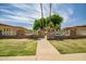 View of the community entrance with brick accents, landscaping, and street signage at 13424 N Emberwood Dr, Sun City, AZ 85351