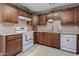 Functional kitchen with dark wood cabinetry, white appliances, and a clean and bright atmosphere at 13608 N 33Rd Ave, Phoenix, AZ 85029