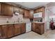Functional kitchen with dark wood cabinetry, white appliances, and a clean and bright atmosphere at 13608 N 33Rd Ave, Phoenix, AZ 85029