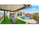 Charming backyard with a pool, fire pit lounge, lush turf, and covered patio, ideal for entertaining at 14587 W Alexandria Way, Surprise, AZ 85379