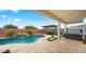 Lush backyard featuring a pristine pool, outdoor seating, and covered patio area perfect for relaxation at 14587 W Alexandria Way, Surprise, AZ 85379
