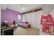Charming bedroom featuring custom doll display shelves and a playful dollhouse for a personalized touch at 14587 W Alexandria Way, Surprise, AZ 85379