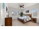 Inviting bedroom features a tropical ceiling fan and a king-size bed with bright botanical patterned comforter at 14587 W Alexandria Way, Surprise, AZ 85379
