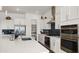Modern kitchen with stainless steel appliances, a spacious island, and custom backsplash at 14587 W Alexandria Way, Surprise, AZ 85379