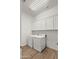 Laundry room featuring modern appliances, wood-look tile flooring, and ample cabinet storage at 14587 W Alexandria Way, Surprise, AZ 85379