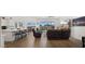 Bright living room boasts wood floors, a modern ceiling fan, and glass doors that lead to the outdoor area at 14587 W Alexandria Way, Surprise, AZ 85379