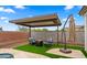 Inviting patio with stylish seating, a cozy fire pit, covered pergola and umbrella for outdoor relaxation at 14587 W Alexandria Way, Surprise, AZ 85379