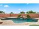 Inviting backyard pool featuring a rock waterfall, tiled surround, and lush landscaping for relaxation at 14587 W Alexandria Way, Surprise, AZ 85379