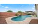 Backyard pool featuring a rock waterfall, manicured landscaping, and cozy seating area at 14587 W Alexandria Way, Surprise, AZ 85379