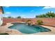 Beautiful backyard pool with rock waterfall feature, surrounded by tiled decking, offering serene outdoor living at 14587 W Alexandria Way, Surprise, AZ 85379