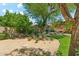 Landscaped backyard with lush lawn, mature trees, desert landscaping, and tranquil seating area at 14655 S 25Th Way, Phoenix, AZ 85048