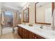 Functional bathroom with double sinks, wood vanity, shower, and tub combination, offering convenience and style at 14655 S 25Th Way, Phoenix, AZ 85048