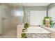 Well-lit bathroom featuring a soaking tub, large window, decorative tile accents, and a glass-enclosed shower at 14655 S 25Th Way, Phoenix, AZ 85048