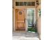 Inviting front entry with a rustic wooden door, sidelight window, and decorative floral arrangement at 14655 S 25Th Way, Phoenix, AZ 85048