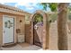 Inviting front entrance with decorative gate and lush greenery, showcasing curb appeal at 14655 S 25Th Way, Phoenix, AZ 85048