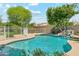 This home's swimming pool features waterfalls, mature trees, and a stone edge at 14655 S 25Th Way, Phoenix, AZ 85048