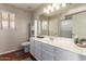 Bathroom featuring white vanity with white countertop, undermount sink and a large mirror at 16661 W Belleview St, Goodyear, AZ 85338