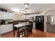 Bright kitchen featuring tile floors, white cabinets, black appliances, and modern lighting at 16661 W Belleview St, Goodyear, AZ 85338