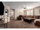 Spacious living room with carpet floors, neutral color palette, ceiling fan, and ample natural light at 16661 W Belleview St, Goodyear, AZ 85338