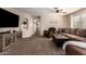 Spacious living room with carpet floors, neutral color palette, ceiling fan, and ample natural light at 16661 W Belleview St, Goodyear, AZ 85338