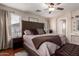 Main bedroom featuring neutral walls, tufted headboard, area rug and ceiling fan at 16661 W Belleview St, Goodyear, AZ 85338