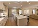 Bright open-concept kitchen boasts a large quartz island, modern appliances, and seamless flow into the dining and living areas at 17911 N Adobe Mesa Ct, Surprise, AZ 85374