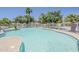 Large community pool surrounded by lush landscaping, white fencing, and comfortable lounge chairs for residents at 17970 N 114Th Ln, Surprise, AZ 85378