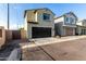 Exterior shot of a two-story home featuring a dark garage door, tile roof, and low maintenance desert landscape at 17970 N 114Th Ln, Surprise, AZ 85378