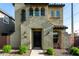 Stucco home featuring an elegant front door, stylish sconces, and desert landscaping at 17970 N 114Th Ln, Surprise, AZ 85378