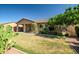 Lush backyard with mature trees, a covered patio, and a well-maintained lawn at 17985 W Ivy Ln, Surprise, AZ 85388