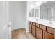 The bathroom is equipped with double sinks, wooden cabinets, and a large mirror at 17985 W Ivy Ln, Surprise, AZ 85388