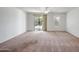 A spacious bedroom is enhanced with an open window and sliding glass door leading to the backyard at 17985 W Ivy Ln, Surprise, AZ 85388