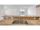 Close-up of a granite kitchen countertop with a stainless steel sink, overlooking a living area and window at 17985 W Ivy Ln, Surprise, AZ 85388