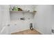 Compact laundry room with upper shelving and tile flooring at 17985 W Ivy Ln, Surprise, AZ 85388