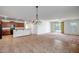 Open-concept living area featuring tile flooring and abundant natural light, leading to kitchen at 17985 W Ivy Ln, Surprise, AZ 85388