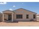 View of the back of the home with a covered patio, neutral stucco, and a spacious dirt backyard ready for landscaping at 18492 E Donato Dr, Gold Canyon, AZ 85118