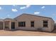 View of the back of the home with a covered patio, neutral stucco, and a spacious dirt backyard ready for landscaping at 18492 E Donato Dr, Gold Canyon, AZ 85118