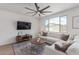 Living room with a comfortable gray sectional sofa, large ceiling fan, and modern decor at 18492 E Donato Dr, Gold Canyon, AZ 85118