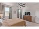 Comfortable main bedroom with a ceiling fan, two windows, carpet, and a large dresser with a television at 18492 E Donato Dr, Gold Canyon, AZ 85118
