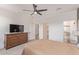 Main bedroom with a ceiling fan, adjacent bathroom, walk-in closet, soft carpet and modern furniture at 18492 E Donato Dr, Gold Canyon, AZ 85118