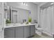 Bright bathroom featuring a double vanity, spacious mirror, and a shower with a curtain at 19203 W Jackson St, Buckeye, AZ 85326