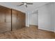 Comfortable bedroom with hardwood floors, custom wood built-ins, a ceiling fan, and serene lighting at 19203 W Jackson St, Buckeye, AZ 85326