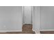 Hallway featuring a door, wood floors, light grey walls, and electrical outlets on the lower part of the wall at 19203 W Jackson St, Buckeye, AZ 85326