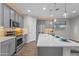 Modern kitchen with sleek gray cabinets, a large island, pendant lighting, and stainless steel appliances at 19203 W Jackson St, Buckeye, AZ 85326