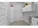 Clean laundry room with storage cabinets and utility sink at 19203 W Jackson St, Buckeye, AZ 85326