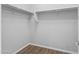 A simple walk-in closet featuring wood floors and metal bars for hanging clothes and storage at 19203 W Jackson St, Buckeye, AZ 85326